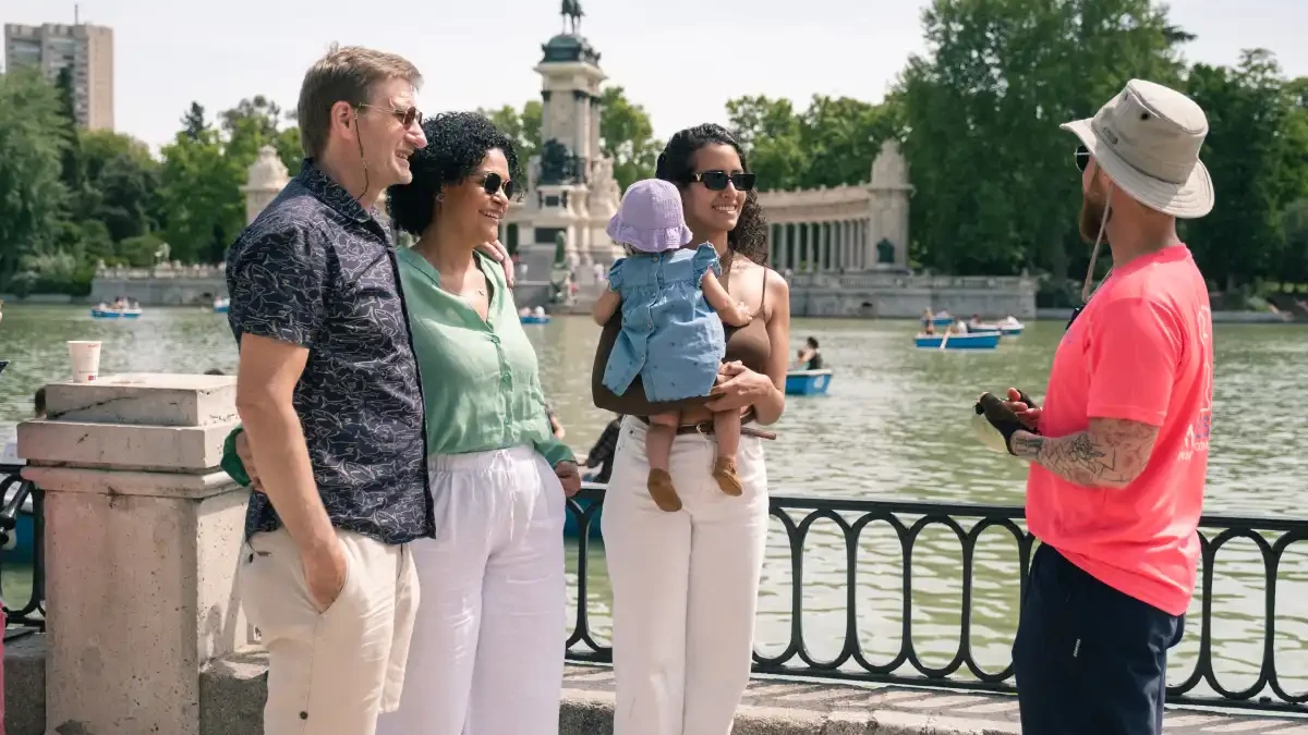 Gezin pauzeert bij de roeivijver in het Retiro-park tijdens de fietstour